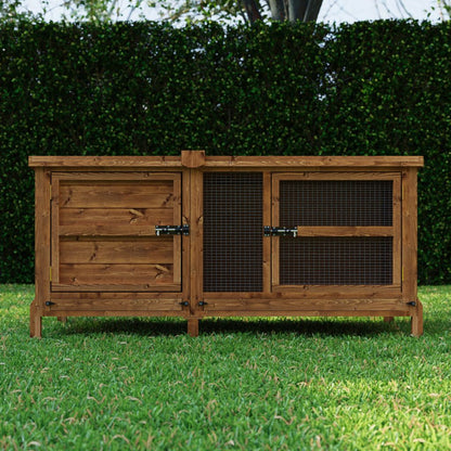 Wooden rabbit hutch on grass with green hedge in the background